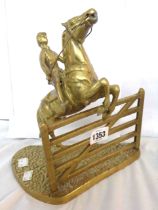 A cast brass figurine, depicting a horse and rider vaulting a gate