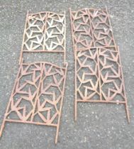 A set of four cast iron trellis panels with pierced prunus decoration