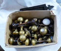 A box containing a quantity of old brass, ceramic and Bakelite doorknobs and a cast iron letter box