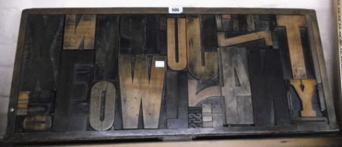 An old wooden printer's tray inset with various letter printing blocks