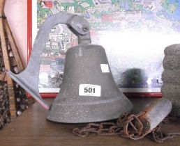 An old porch bell with chain and wooden handle