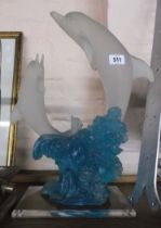 A perspex and resin figurine, depicting a pair of dolphins leaping from the waves