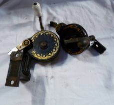 Two old sewing machine hand cranks with gilt decoration on a black ground, one with ceramic