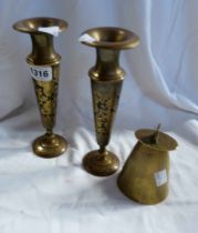 A pair of brass candlesticks with floral decoration on a black enamel ground - sold with a brass