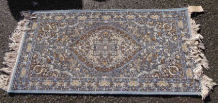 A modern Keshan machine made rug with central medallion within a border on cream ground - 1.35m X