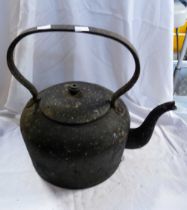 A large old cast iron kettle with black painted finish