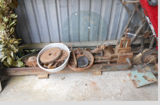 A large old metal lathe with heavy cast iron base