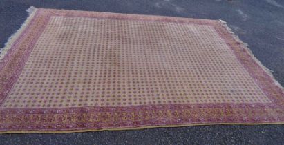 A vintage Romanian han made wool carpet with repeat geometric flowerhead design within a triple