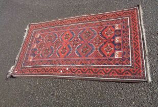 A vintage Afghan handmade wool rug with repeat gul motifs within a double border on red ground - 1.