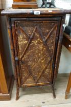 A 48cm 19th Century bamboo cupboard with shelves enclosed by a woven rush panelled door, set on