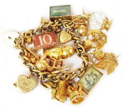 A 375 (9ct.) gold kerb-link charm bracelet with numerous 375 and other charms including encapsulated