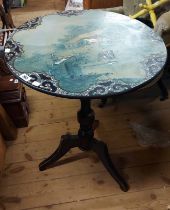 A 60cm diameter Victorian japanned and mother-of-pearl inlaid tilt-top pedestal table with painted