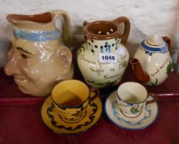 A small quantity of Torquay pottery including Watcombe puzzle jug, character jug, teapot, etc.