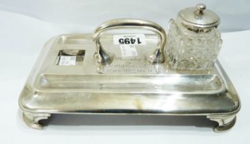 A silver inkstand with central loop handle, flanking pen depressions and one of two original