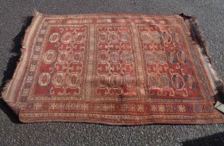 An antique Afghan handmade wool Kelim with three panels of gul motifs within borders on red ground -