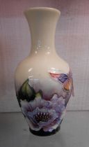 A small Old Tupton Ware vase with tube-lined floral and butterfly decoration on a cream and purple