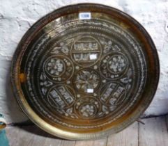 A wall hanging brass tray with decorative Arabian embossing
