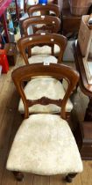 A set of four late Victorian mahogany framed dining chairs with carved cross rails and overstuffed