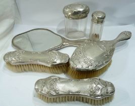 A harlequin four piece Art Nouveau silver mounted hand mirror and brush set, also with two silver