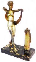 An Art Deco spelter figural table lighter of strike form, depicting a stylish dancing lady with