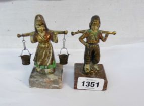 A pair of cast brass and painted figurines, depicting Dutch children carrying buckets, each set on