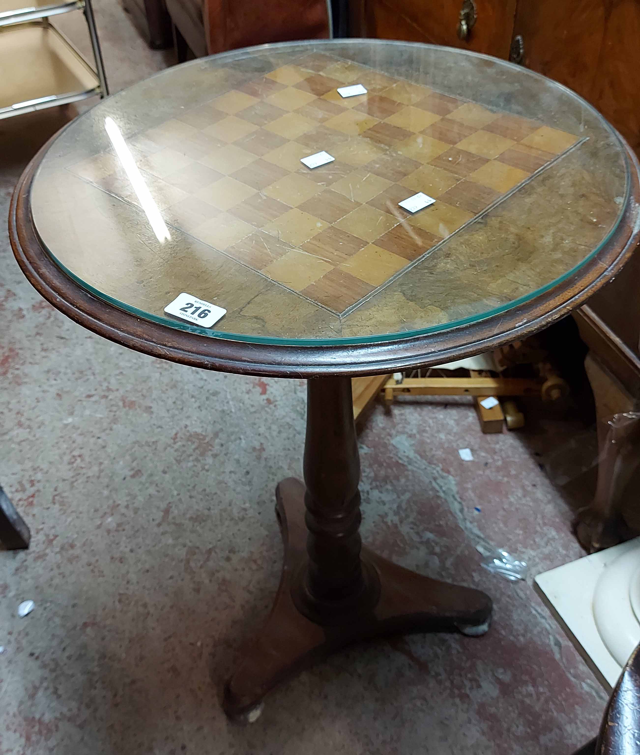 A 52cm diameter antique mahogany pedestal games table with inlaid chessboard top, set on turned