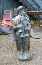 A garden statue depicting a medieval boy playing bagpipes