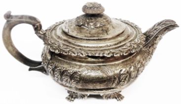 A late Georgian silver teapot with ornate cast and embossed decoration with wooden knop and