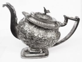 A George III ornate silver teapot with embossed and applied grapevine decoration, bird pattern
