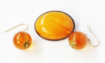 A vintage white metal framed amber cabochon oval panel brooch - sold with a pair of amber drop