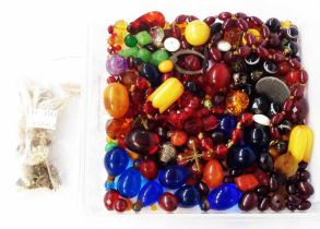 A tub containing a quantity of loose jewellery beads including glass, amber, polyester, hardstone,