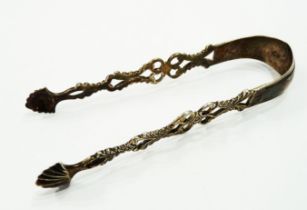 A pair of antique Irish silver sugar tongs with decorative pierced sides and shell pattern nips -