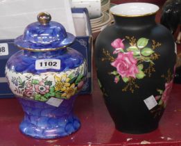 A Maling pottery lidded jar decorated with a central floral band on a blue sponge lustre ground -