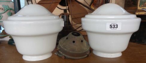 A pair of opaque milk glass shades with metal fittings