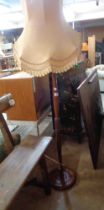 A vintage stained wood standard lamp, set on turned pillar and circular base - sold with shade
