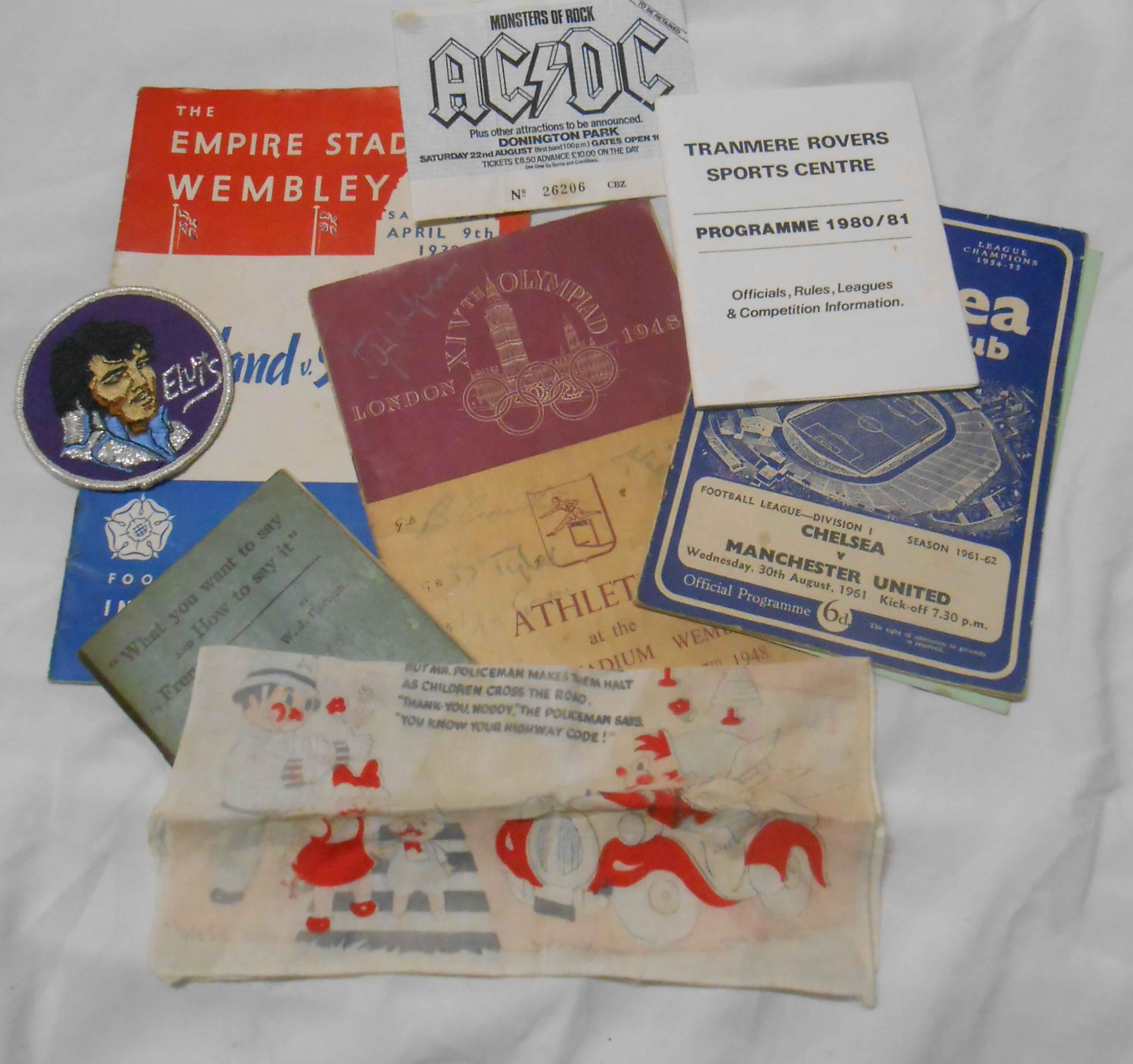 A small bag of ephemera including AC/DC concert ticket, football programmes and an Elvis cloth