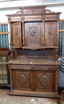 A 1.4m 20th Century French ornate carved oak break top two part cabinet with triple cupboard to