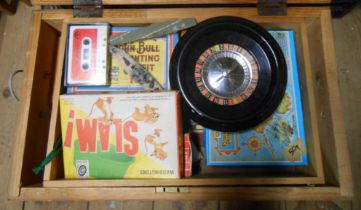 A wooden box containing a quantity of games and toys