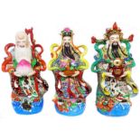 A set of three 20th Century Chinese porcelain deity figures, each depicted standing on a watery base