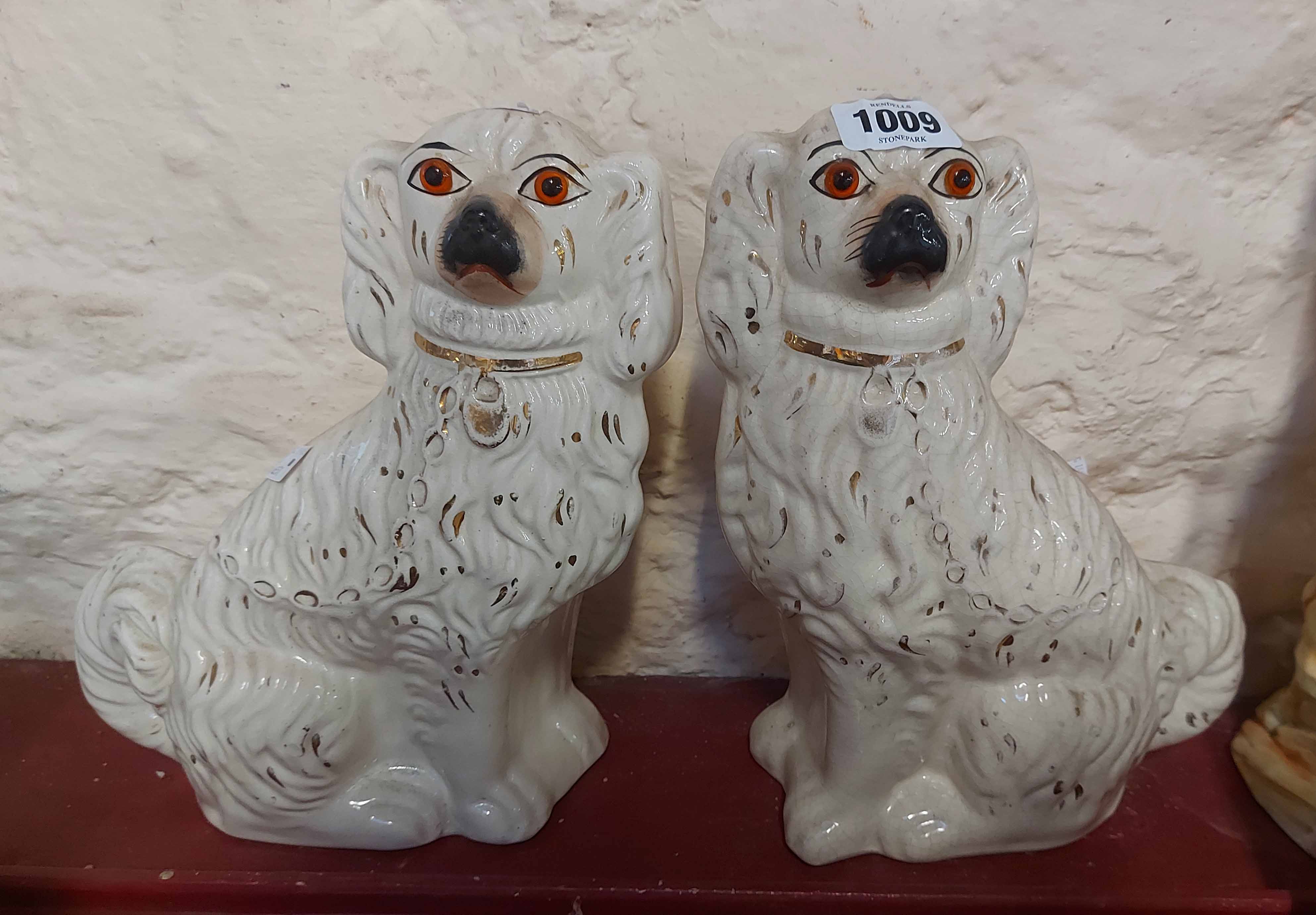 A pair of Staffordshire comforter spaniels with gilt decoration and glass eyes