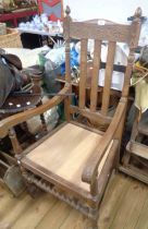 A vintage oak high lathe back elbow chair with incised decoration and replacement seat panel, set on