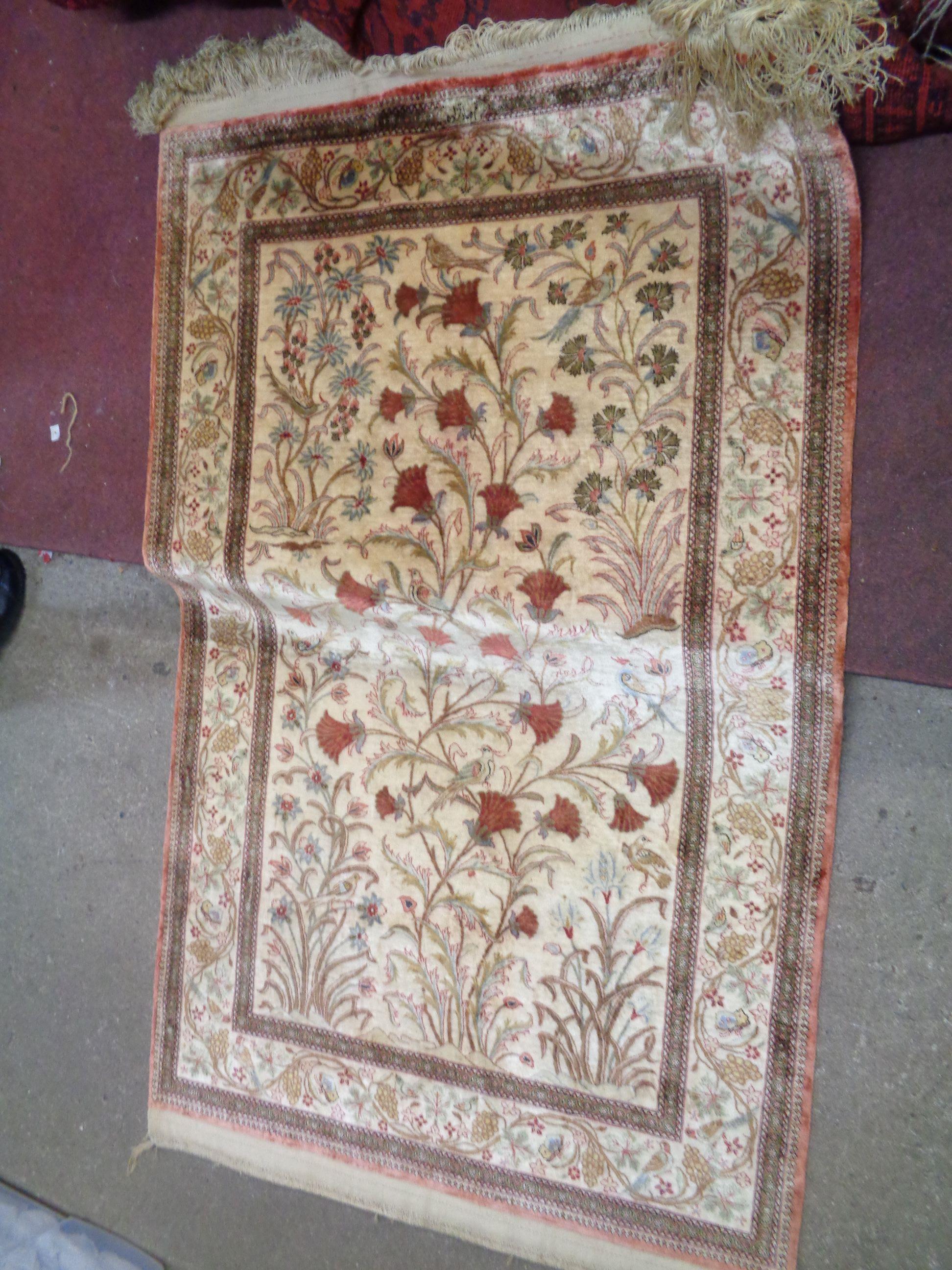 A 20th Century Oriental handmade silk on cotton rug with directional central decoration depicting