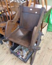 An antique stained oak Glastonbury chair with panel back and solid seat, set on pegged supports -
