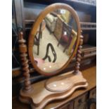 A Victorian mahogany oval swing dressing table mirror with barley twist supports and lift-top