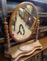 A Victorian mahogany oval swing dressing table mirror with barley twist supports and lift-top