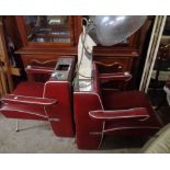 A pair of vintage salon hairdresser's chairs, upholstered in red leatherette - sold as a collector's