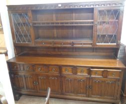 A 1.92m vintage oak two part dresser with central two shelf open plate rack, flanking leaded