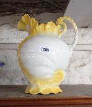 A pottery toilet jug with shell form decoration and yellow finish