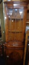 A 66cm reproduction yew corner cabinet with shelves enclosed by a beaded glazed panel door and