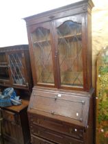 An 87cm early 20th Century oak two part bureau bookcase with shelves enclosed by a pair of leaded